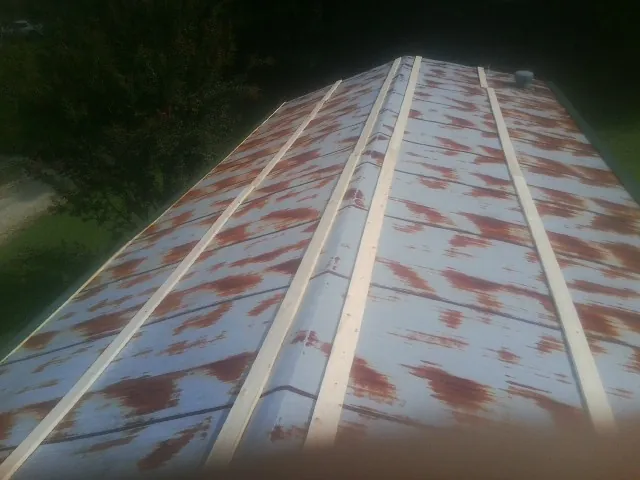 Rusted metal roof panels with new wood purlins before replacement — Storm Damage Roof Repair in Wharton by Roofing Brothers