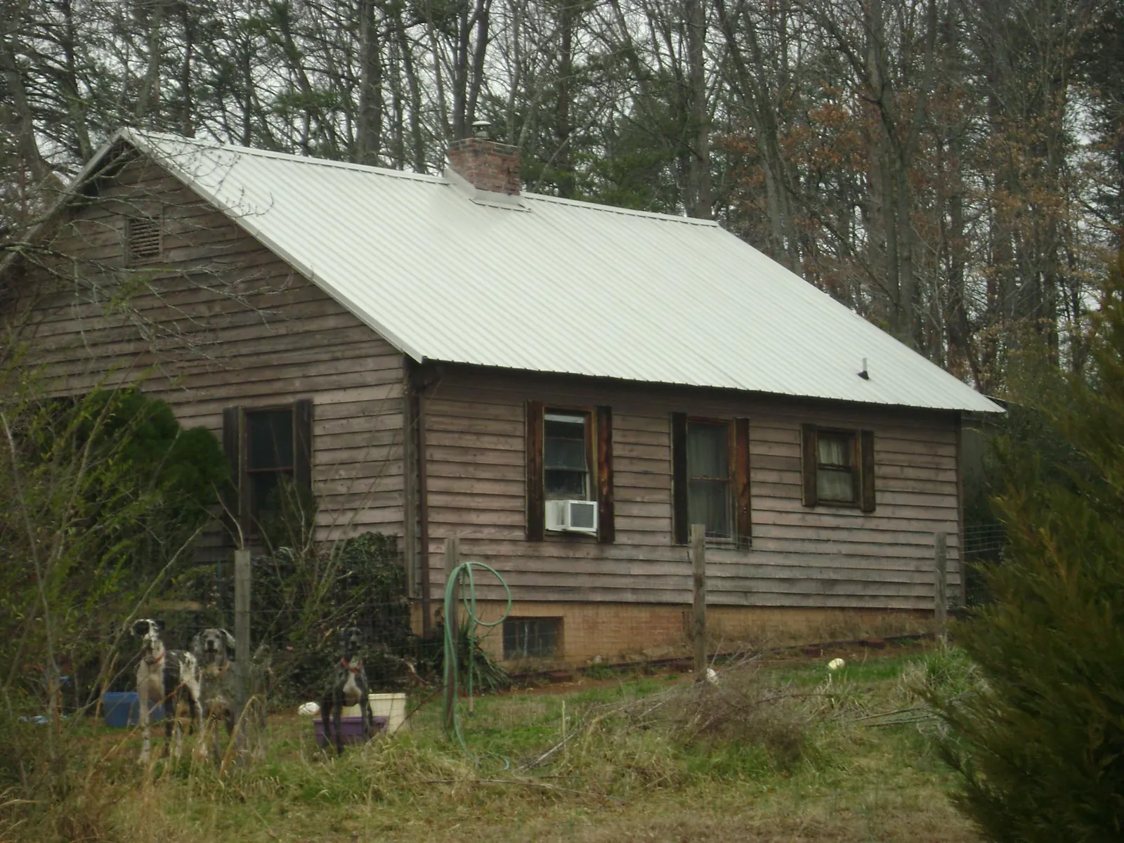 White metal roof on an old wood sided farmhouse, from a Metal Roof Installation job in Wharton